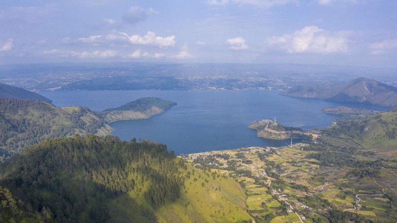 WISATA MENARA PANDANG TELE DI DANAU TOBA Foto aerial Danau Toba dari kawasan wisata menara pandang Tele di Turpuk Limbong, Harian, Kabupaten Samosir, Sumatera Utara, Minggu (21/2/2021). Wisata menara pandang tersebut menyajikan keindahan panorama Danau Toba hingga pegunungan Samosir dari atas ketinggian yang dapat dinikmati oleh wisatawan domestik maupun international. ANTARA FOTO/Nova Wahyudi/wsj.