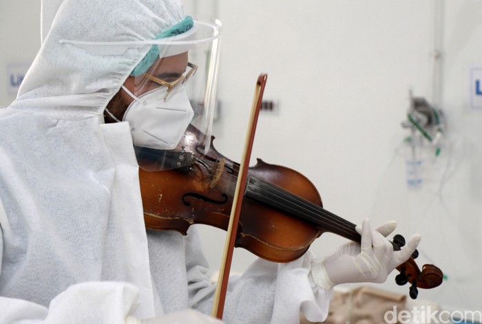 Dr. Mohamed Salah Siala plays the violin for patients on the COVID wards of the Hedi Chaker hospital in Sfax, eastern Tunisia, Saturday Feb. 20, 2021. When the 25-year-old decided to get out his violin one day at Hedi Chaker Hospital in city of Sfax and play, it won praise for boosting the morale of virus sufferers who remained isolated and needed a smile. (AP Photo)