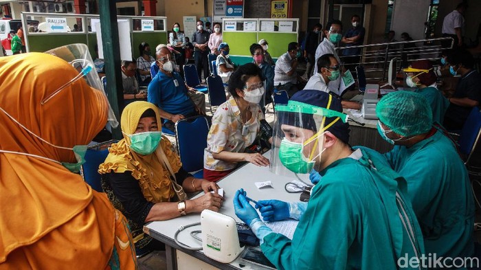 Para lansia antri untuk memperoleh vaksin COVID-19 di RSUD Kembangan, Jakarta Barat, Selasa (23/2/2021). Antrian yang sempat viral pada Minggu (21/2) sudah tidak terlihat lagi. Beberapa lansia mengantre dengan ditemani oleh keluarga yang masih muda.