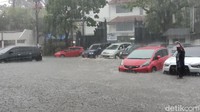 Sementara itu, puluhan motor dan mobil terendam genangan yang terus mengalir. Beberapa terlihat berusaha menyelamatkan kendaraan mereka ke tempat lebih tinggi.