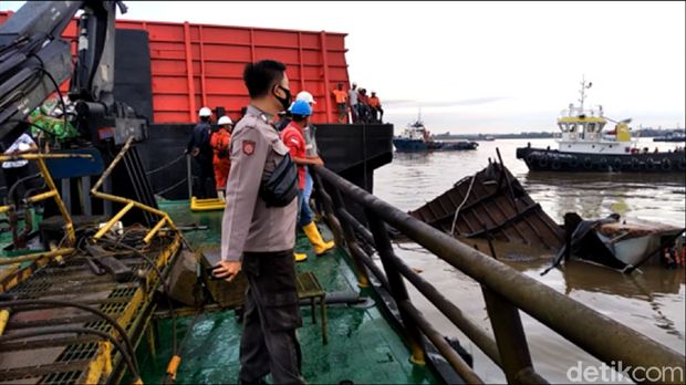 Kapal tongkang yang terbakar dan meledak di dermaga Samarinda tenggelam di Sungai Mahakam. Tim Inafis Polresta Samarinda memasang garis polisi di lokasi (Suriyatman/detikcom)