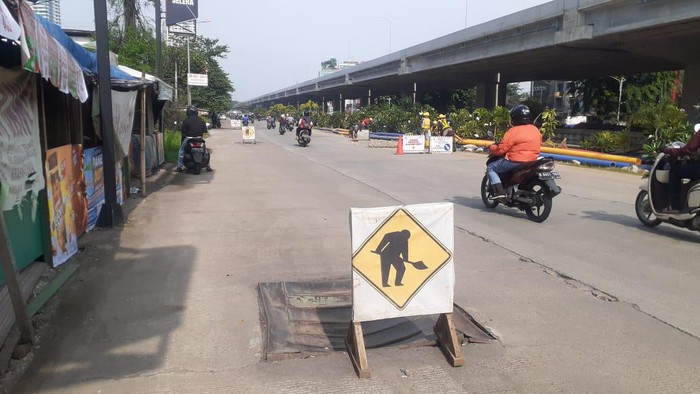 Papan peringatan di tutup gorong-gorong  yang rusak Jl KH Noer Ali di Kalimalang, Kota Bekasi.