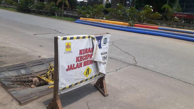 Papan peringatan di tutup gorong-gorong  yang rusak Jl KH Noer Ali di Kalimalang, Kota Bekasi.