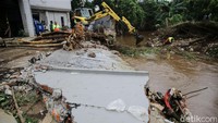 Petugas UPK Badan Air DLH Provinsi DKI Jakarta dengan menggunakan alat berat tengah memperbaiki tembok Kali Krukut yang berada di Jalan Taman Kemang, Jakarta, Selasa (24/2/2021).