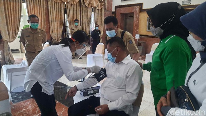Vaksinasi COVID-19 tahap dua digelar hari ini di Surabaya. Petugas pelayanan publik, lansia hingga beberapa kepala OPD pemkot disuntik vaksin.