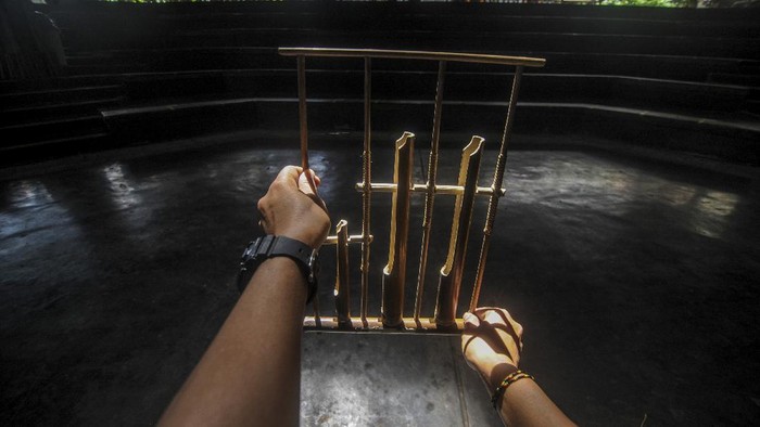 WAJAH MURAM SAUNG ANGKLUNG UDJO DI MASA PANDEMI Seorang instruktur memegang angklung di aula pementasan yang kosong di Saung Angklung Udjo.