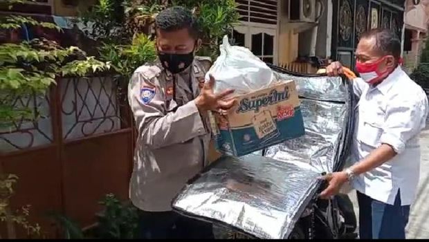 Anggota Bhabinkamtibmas Bripka Parmuji melakukan delivery isoman