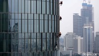 Pekerja membersihkan kaca gedung bertingkat di Jakarta, Selasa (23/2/2021).
