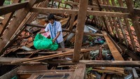 Warga mencari harta benda di dalam rumahnya yang roboh akibat dihantam angin puting beliung di Desa Karangsono, Kecamatan Mranggen, Kabupaten Demak, Jawa Tengah, Rabu (24/2/2021).