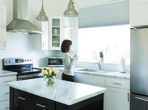 small kitchen in a pool guest house with appliances and cabinets and a counter and custom lighting