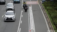 Pembatas itu terpasang berbaris vertikal berimpitan. Terlihat juga barrier plastik oranye turut dipasang sekitar pembatas beton.