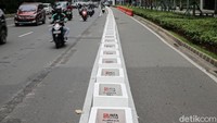 Pembatas ini tidak seluruhnya terpasang. Ada pula celah di antara itu untuk kembali ke jalur kendaraan. Area di depan halte bus juga tidak dipasang pembatas jalur sepeda.