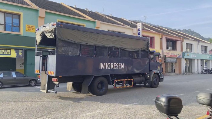 Malaysia Deportasi 1.086 Warga Myanmar In this image taken from a video, an immigration truck with security and unidentified people drives on a road that leads to Lumut Naval Base Tuesday, Feb. 23, 2021 in Lumut, Malaysia. A Malaysian court Tuesday ordered a halt to the planned deportation of 1,200 Myanmar migrants to hear an appeal by two human rights groups, which say the migrants included refugees, asylum seekers and minors. (AP Photo)