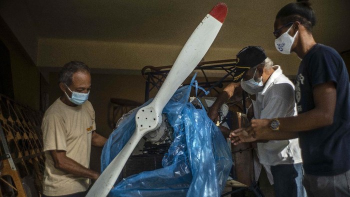 Mimpi Besar Mekanik Kuba Bikin Pesawat Kayu Adolfo Rivera gets out the wooden, two-seater plane he is building in the garage of his apartment building in Havana, Cuba, Friday, Feb. 19, 2021. Rivera, a 70-year-old mechanical engineer, and university professor has been making the wooden, two-seater aircraft for eight years now, with government permission and estimates he has spent about 5,500 Euros ($6,660). (AP Photo/Ramon Espinosa)