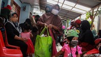Warga membawa sembako yang baru diterima.