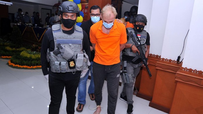 Dua orang warga negara Rusia Andrei Kovalenka alias Andrew Ayer (kedua kanan) dan Ekaterina Trubkina (kedua kiri) dihadirkan petugas saat rilis di Kantor Imigrasi Kelas I Khusus TPI Ngurah Rai, Badung, Bali, Rabu (24/2/2021). Andrei Kovalenka yang juga merupakan buronan Interpol tersebut bersama pasangannya Ekaterina Trubkina berhasil ditangkap di kawasan Seminyak, Bali, usai melarikan diri dari Kantor Imigrasi Ngurah Rai sejak Kamis (11/2) lalu saat proses administrasi pemindahannya ke Rumah Detensi Imigrasi Denpasar untuk menunggu pendeportasian setelah sebelumnya menjalani hukuman pidana di Lapas Kerobokan karena kasus narkotika. ANTARA FOTO/Fikri Yusuf/foc.