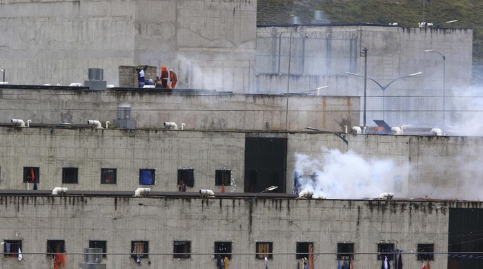 The relatives of prisoners gather outside Turi jail where soldiers stand guard after an inmate riot broke out in Cuenca, Ecuador, Tuesday, Feb. 23, 2021. Deadly riots broke out in prisons in three cities across the country due to fights between rival gangs, according to police. (Boris Romoleroux/API via AP)