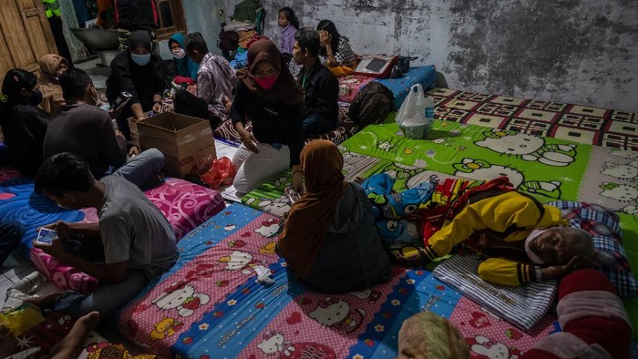 Anggota polisi bersama relawan memasak untuk kebutuhan makan pengungsi korban bencana angin puting beliung di Balai Desa Karangsono, Kecamatan Mranggen, Kabupaten Demak, Jawa Tengah, Selasa (23/2/2021). Ratusan personel gabungan lintas instansi serta berbagai relawan organisasi masyarakat bersiaga membantu para korban dampak hujan deras disertai angin puting beliung yang terjadi pada Selasa (23/2) sore sekitar pukul 15:00 WIB di desa tersebut. ANTARA FOTO/Aji Styawan/aww.