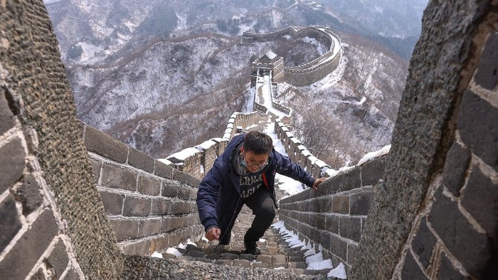 Salju di Tembok Besar China Mulai Mencair BEIJING, CHINA - FEBRUARY 23: A family visits the Mutianyu Great Wall covered in snow on February 23, 2021 in Beijing, China. Affected by the new coronavirus (COVID-19), the number of visitors to Mutianyu Great Wall in 2020 dropped by about 60%. (Photo by Lintao Zhang/Getty Images)