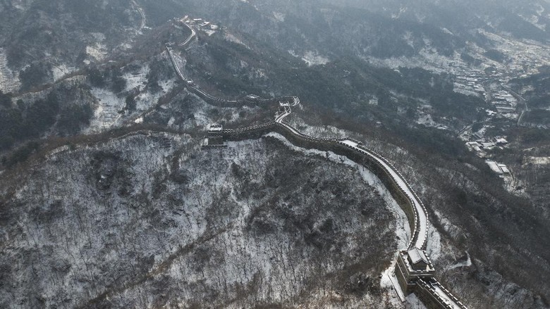Salju di Tembok Besar China Mulai Mencair BEIJING, CHINA - FEBRUARY 23: A family visits the Mutianyu Great Wall covered in snow on February 23, 2021 in Beijing, China. Affected by the new coronavirus (COVID-19), the number of visitors to Mutianyu Great Wall in 2020 dropped by about 60%. (Photo by Lintao Zhang/Getty Images)