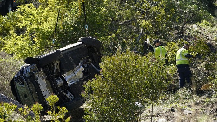 tiger woods kecelakaan,tiger woods,golf Workers collect debris beside a vehicle after a rollover accident involving golfer Tiger Woods Tuesday, Feb. 23, 2021, in Rancho Palos Verdes, Calif., a suburb of Los Angeles. Woods suffered leg injuries in the one-car accident and was undergoing surgery, authorities and his manager said. (AP Photo/Marcio Jose Sanchez)