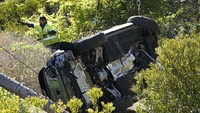 Petugas memeriksa mobil SUV milik Tiger Woods yang keluar jalanan di kawasan Rolling Hills Estates dan Rancho Palos Verdes, Los Angeles, Amerika Serikat. (Foto: Marcio Jose Sanchez/AP)