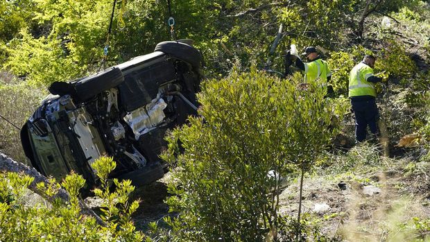 A vehicle is towed away from the site of a crash involving golfer Tiger Woods, Tuesday, Feb. 23, 2021, in the Rancho Palos Verdes suburb of Los Angeles. (AP Photo/Ashley Landis)