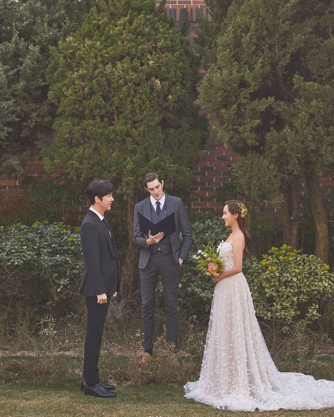 Ini penampakan Oh Yoon Hee (pemain Eugene) dan Ha Yoon Cheol (pemain Yoon Jong Hoon) saat bersanding di hadapan penghulu. Gaun putih yang dukenakan Oh Yoon Hee terlihat simpel dan elegan, dengan rok panjang yang menjuntai. Foto: dok. SBS
