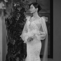 Ini gaun yang dikenakan Cheon Seo Jin (pemain Kim So Yeon) dalam foto pre wedding, bersama suaminya Joo Dan Tae (pemain Uhm Ki Joon). Gaun putih berbahan lace ini semakin mewah dengan aksen cape berbahan tulle di bagian bahu. Foto: dok. SBS