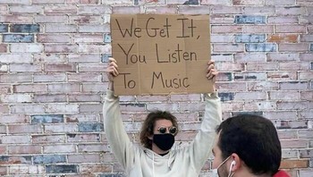 Kayaknya pria yang sedang memakai earphone itu langsung tersindir. Foto: Instagram/@dudewithsign via Bored Panda