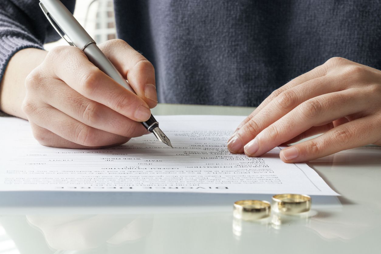 Wife signs divorce decree form with ring