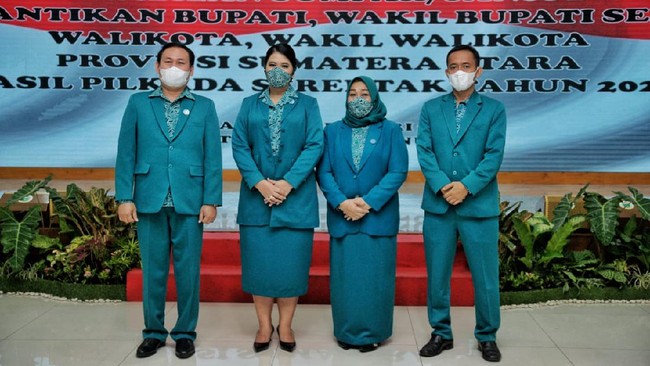 Menjalankan protokol kesehatan, ibu dua anak ini pun memakai masker yang motifnya senada dengan blouse. Sepatu hitam berhak pendek ikut menemani penampilannya. (Foto: Dok. Kominfo Medan)