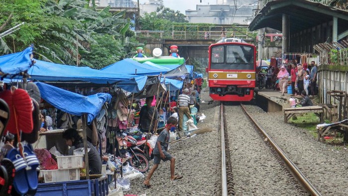 PASAR PINGGIR REL KERETA Pedagang menata barang-barang di pasar kaget pinggir rel kawasan Citeureup, Kabupaten Bogor, Jawa Barat, Jumat (26/2/2021). Pedagang nekat menjajakan dagangan di lokasi tersebut meskipun beresiko dan mengganggu lalu lintas kereta. ANTARA FOTO/Yulius Satria Wijaya/rwa.