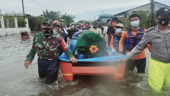 Perahu dikerahkan untuk membantu proses pemakaman jenazah warga yang terdampak banjir di Kota Semarang, Jawa Tengah, Jumat (26/2/2021).