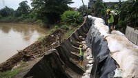 Tanggul ditambal dengan karung berisi pasir.