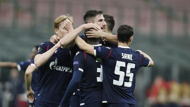 Red Star Belgrade Red Star's El Fardou Ben, covered by his teammates celebrates after scoring his side's opening goal during the Europa League round of 32 second leg soccer match between AC Milan and Red Star Belgrade at the San Siro Stadium, in Milan, Italy, Thursday, Feb. 25, 2021. (AP Photo/Antonio Calanni)