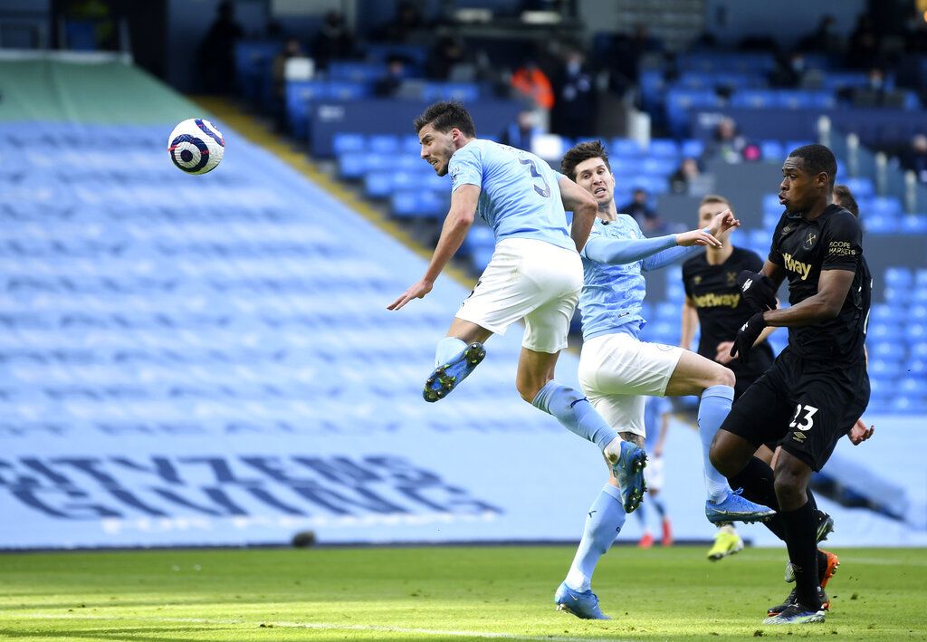 Manchester City's Ruben Dias, left, scores his side's opening goal during the English Premier League soccer match between Manchester City and West Ham United at the Etihad stadium in Manchester, England, Saturday, Feb. 27, 2021. (Gareth Copley/Pool via AP)