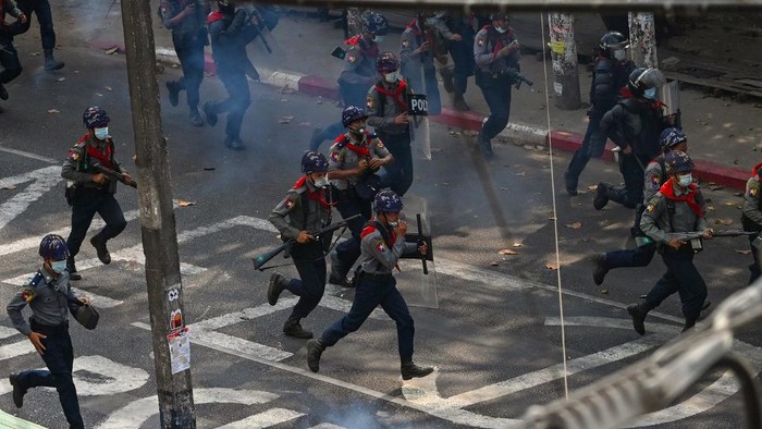 Police run to disperse protesters as they crack down on demonstrations against the military coup in Yangon on February 27, 2021. (Photo by Sai Aung Main / AFP)