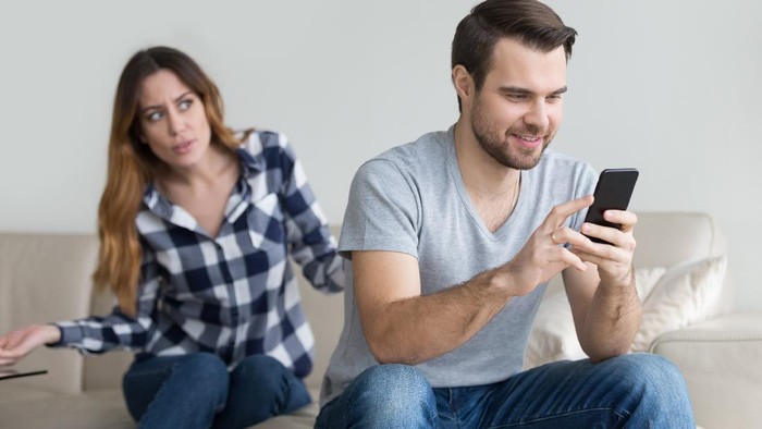 Jealous suspicious mad wife arguing with obsessed husband holding phone texting cheating on cellphone, distrustful girlfriend annoyed with boyfriend mobile addiction, distrust social media dependence