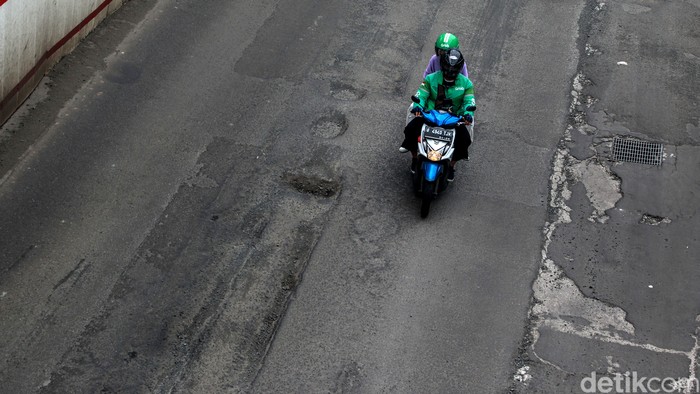 Para pengendara berjalan pelan saat menghindari jalan rusak di depan Setiabudi One, Jalan Rasuna Said, Jakarta Selatan, Senin (1/3/2021).