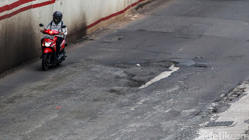 Para pengendara berjalan pelan saat menghindari jalan rusak di depan Setiabudi One, Jalan Rasuna Said, Jakarta Selatan, Senin (1/3/2021).