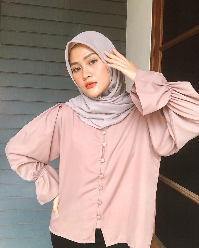 Warna pastel selalu menjadi andalannya mulai dari blouse dan hijab. Kali ini Henny memakai hijab segi empat warna sand beige dan blouse nude kancing depan dengan detail kerut pada lengan. Foto: Instagram @hennyyrahman.