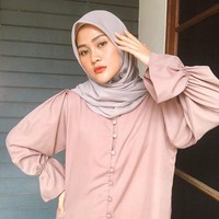 Warna pastel selalu menjadi andalannya mulai dari blouse dan hijab. Kali ini Henny memakai hijab segi empat warna sand beige dan blouse nude kancing depan dengan detail kerut pada lengan. Foto: Instagram @hennyyrahman.