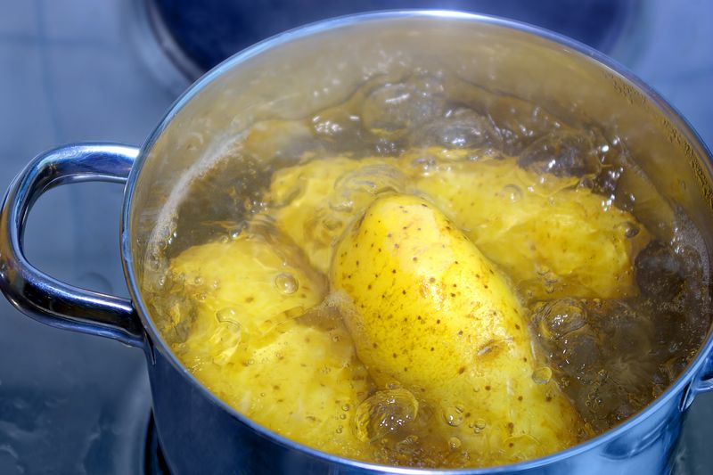 Kartoffeln werden in einem Kochtopf gekocht. Potatoes are cooked in a cooking pot.