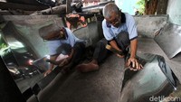 Seorang perajin memotong aluminium untuk dibuat peralatan dapur di Semanggi, Solo, Jawa Tengah, Senin (1/3/2021).
