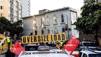 Setelah sampai di lokasi, proses yang dilakukan selanjutnya relatif sama: menurunkan rumah dari truk yang mengangkutnya, lalu pelan-pelan menaruhnya di lokasi yang baru. Untuk memindahkan rumah ke lokasi yang baru, sang pemilik merogoh kocek cukup dalam. (AP)