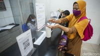 Usai menerima dana pun orang tua dan anak menggunakan cairan desinfektan.