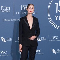 Aktris Rosamund Pike tampil super seksi dengan jas tuksedo dan celana htam berpotongan lebar. Tanpa baju dalaman, ia mengekspos dada yang memberi aura seksi tapi tetap elegan. Foto: Jeff Spicer/Getty Images