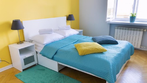 Traditional colorful bedroom with bed, pillows and towels