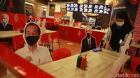 Pramusaji menyiapkan meja dengan kursi yang diberi foto tokoh dunia sebuah restoran di Kuningan City, Jakarta, Selasa (2/3/2021).